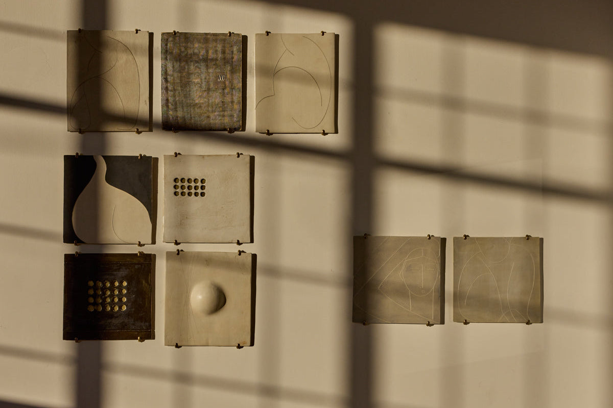 Set of geometric wall art pieces casting shadows on a wall.